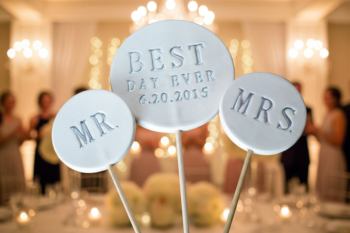 Three round wedding toppers labeled 'MR', 'BEST DAY EVER', wedding date and 'MRS' .