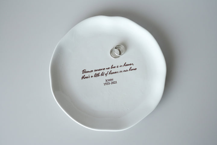 White dish with engraved text on a smooth surface