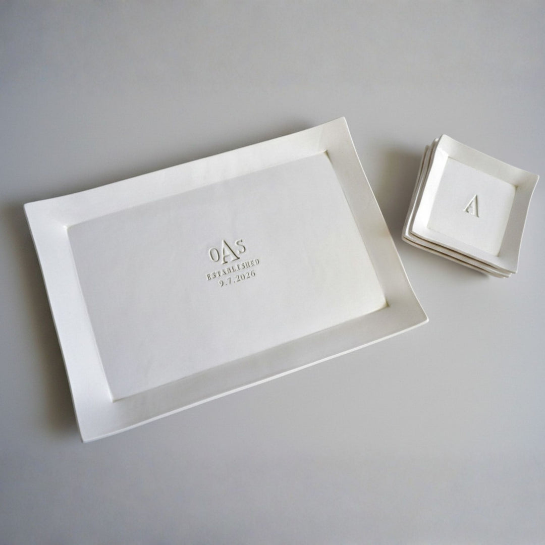 White rectangular tray with engraved initials and date on a gray background