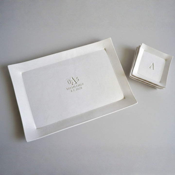 White rectangular tray with engraved initials and date on a gray background