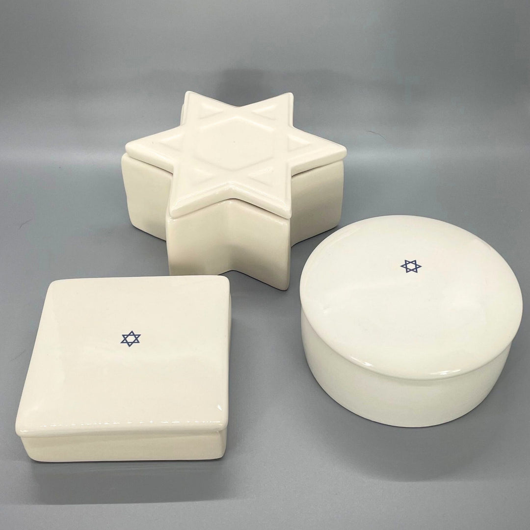 Three ceramic jewelry boxes with star designs on a gray background