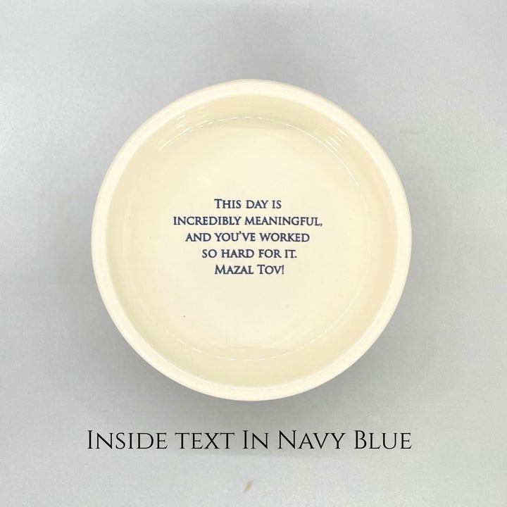 Round ceramic box bottom with navy blue text on a gray background