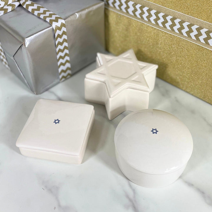 Three ceramic keepsakes with a star design on a white surface.