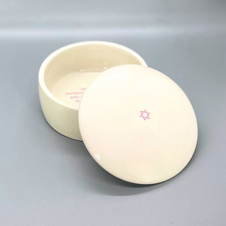 Round white ceramic keepsake box with lid on a gray background