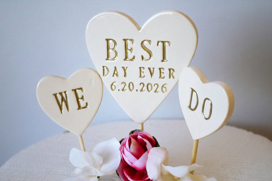 Wedding cake topper with 'Best Day Ever' and 'We Do' hearts