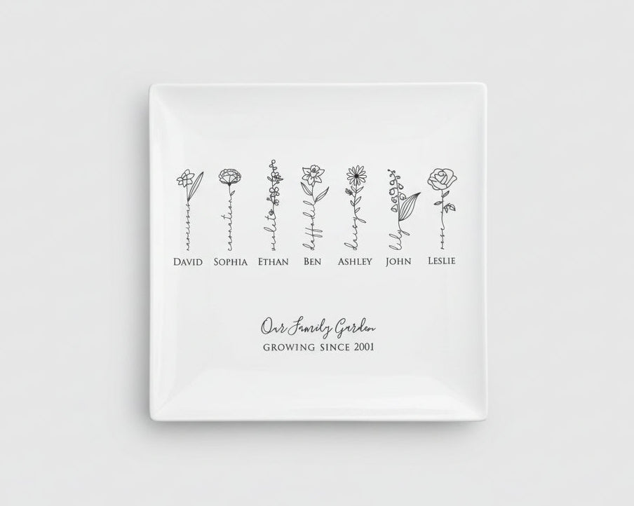White square plate with black floral designs and names on a light gray background