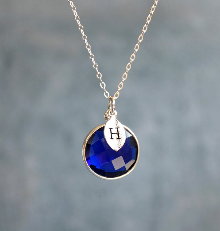 Necklace with a blue pendant and gold chain on a blurred background