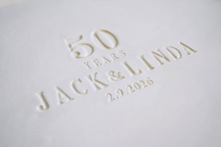 Embossed text on a white surface reading '50 years Jack & Linda 2.9.2026'.