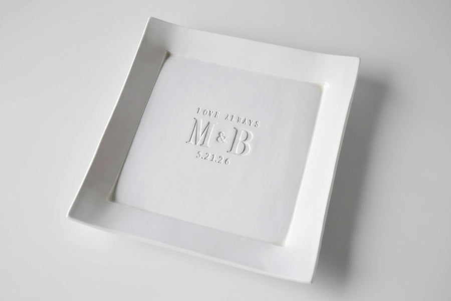 White square plate with 'M&B' debossed on a handmade ceramic