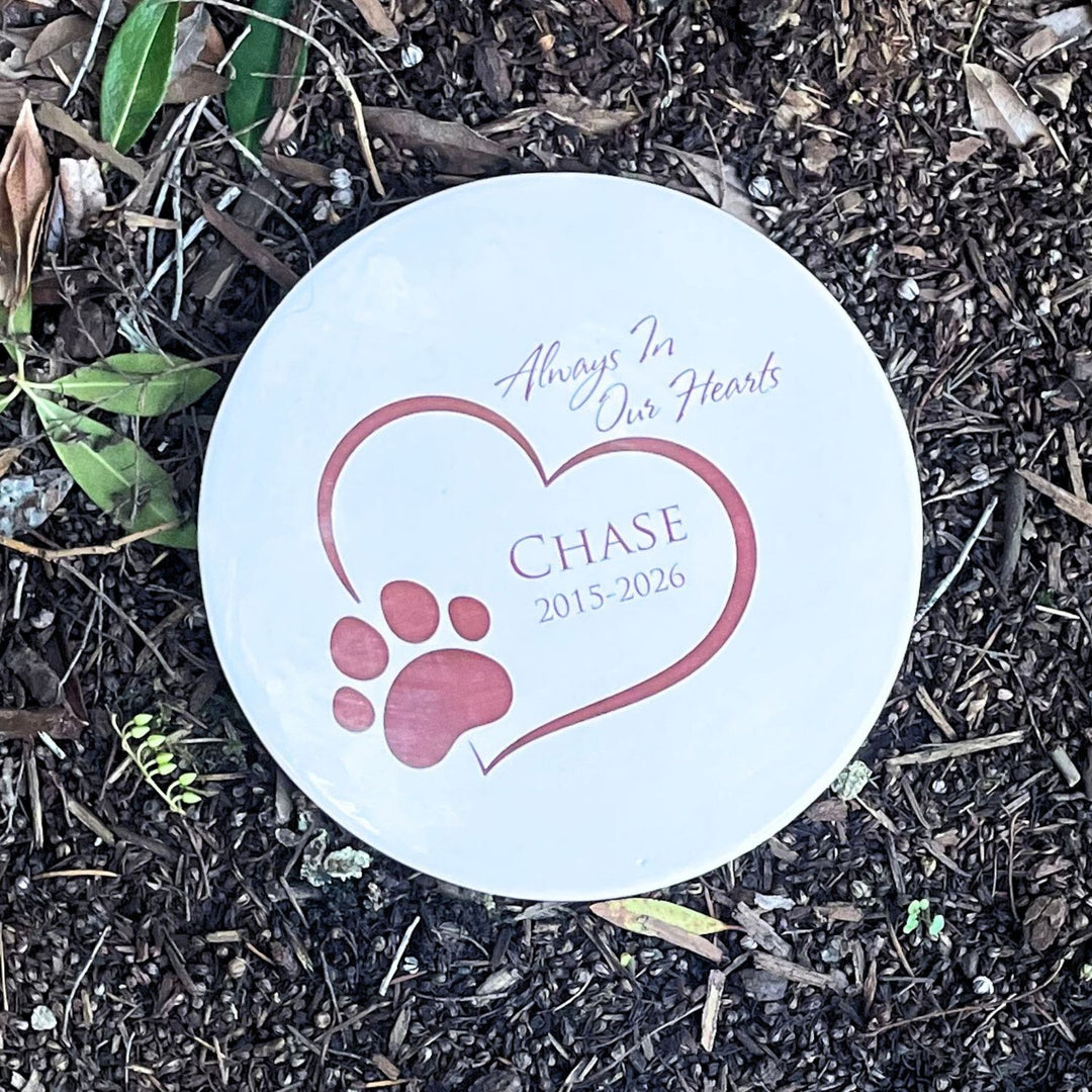 Personalized Memorial plaque on a bed of soil and leaves.