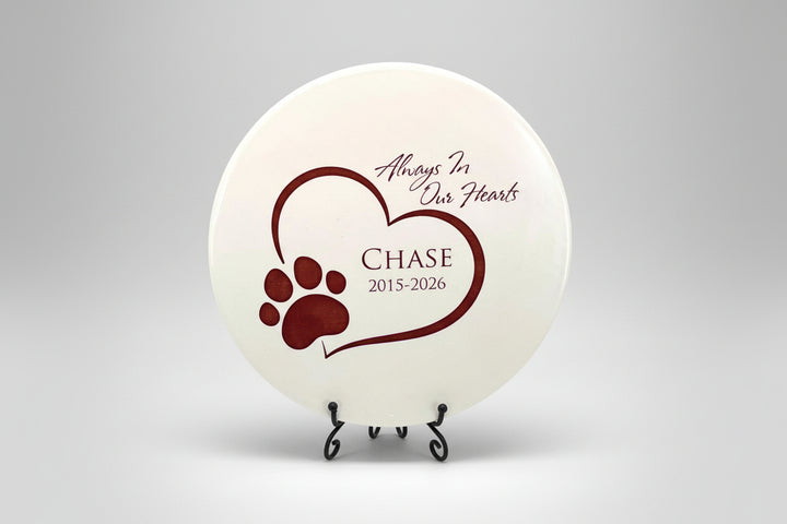 Memorial plaque with paw print and text 'Always In Our Hearts Chase 2015-2026' on a white background