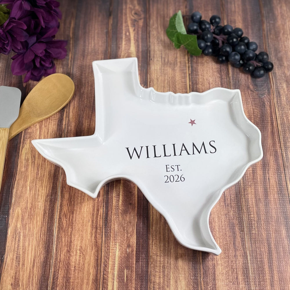 White ceramic Texas-shaped platter with 'Williams' and 'Est. 2026' text on a wooden surface.