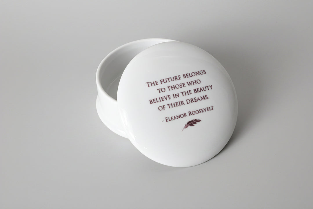 White decorative box with a quote by Eleanor Roosevelt on a marble surface.