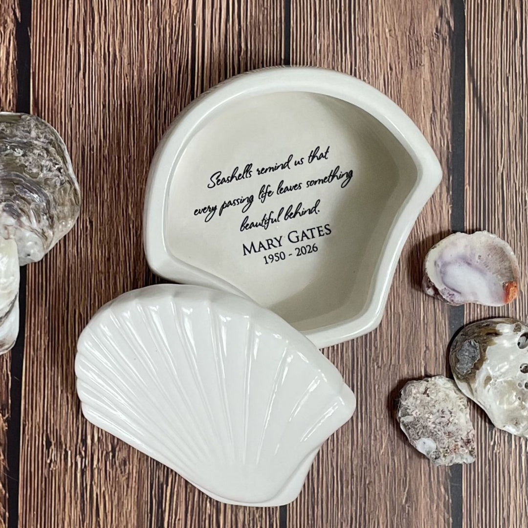 Shell-shaped decorative piece with engraved text on a wooden surface