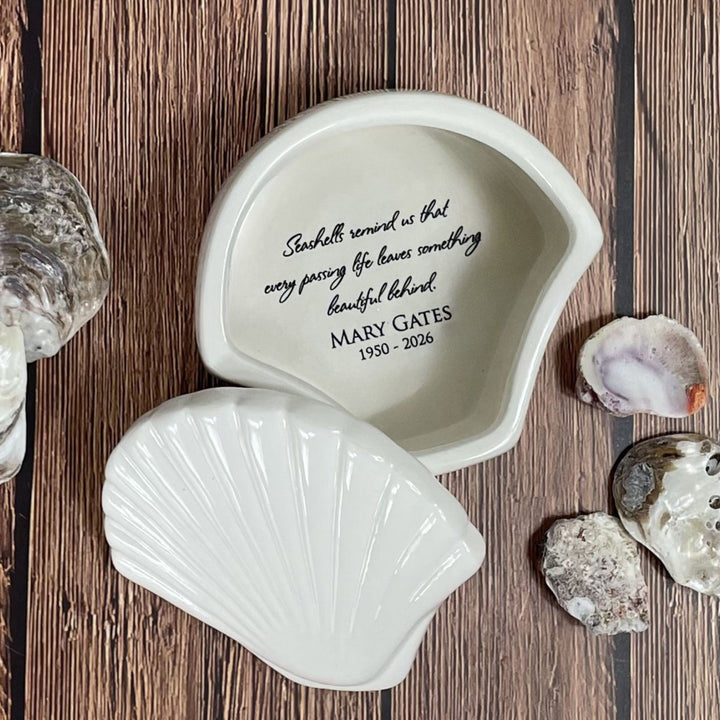 Shell-shaped decorative piece with engraved text on a wooden surface