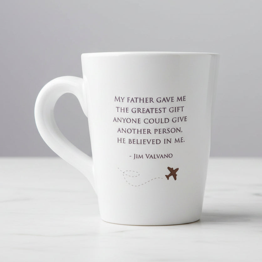 White mug with a quote by Jim Valvano on a wood
