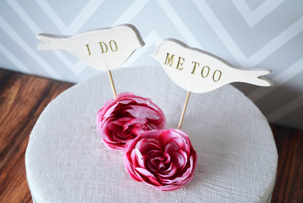Two pink roses with 'I Do' and 'Me Too' cake toppers .
