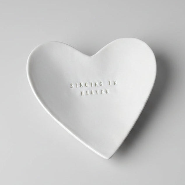 Heart-shaped white ceramic dish on a light gray background